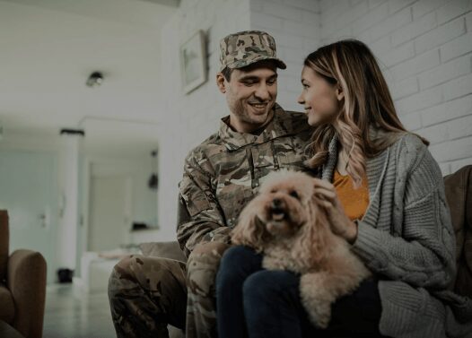 Soldier and woman with dog at home.